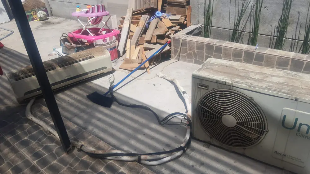 Unidad exterior en una terraza con sus cañerías y conexión