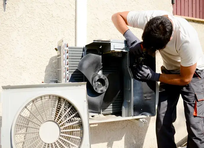 Técnico reparando una condensadora abierta