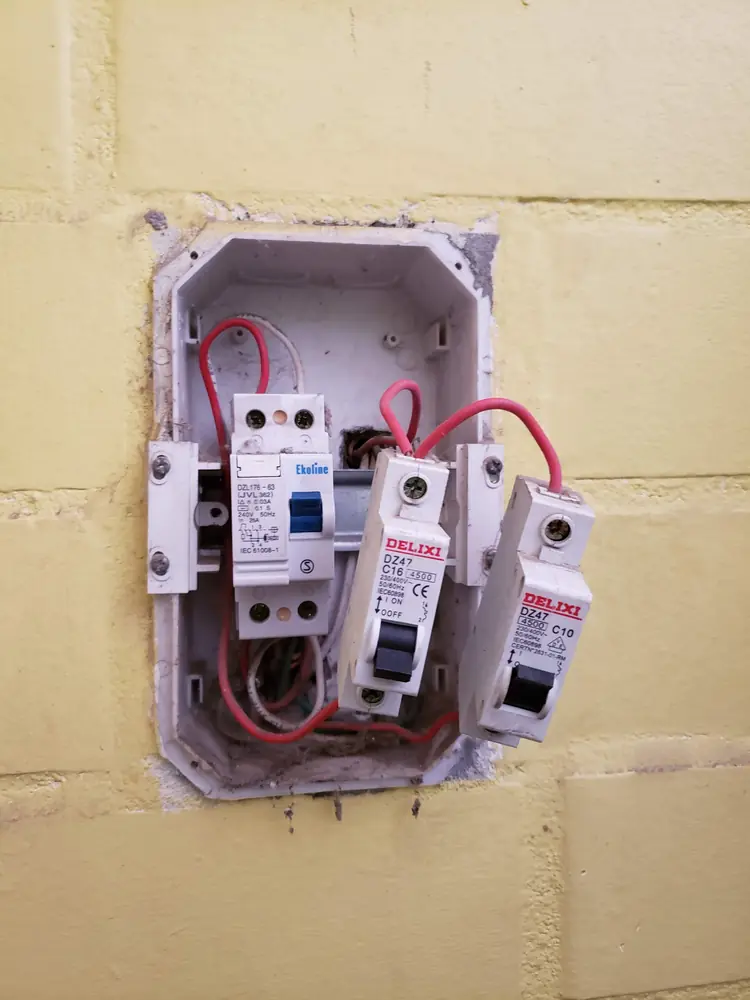 Tablero pequeño en muro de ladrillo con diferencial y automáticos