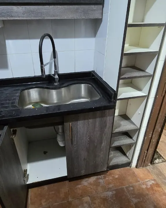 Cocina con el lavaplatos y el piso reparado frente al mueble