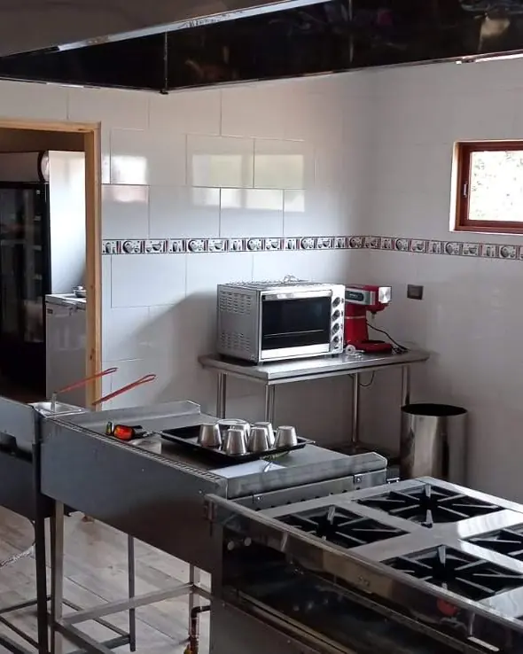 Cocina de restaurante con quemadores industriales y mesones de acero