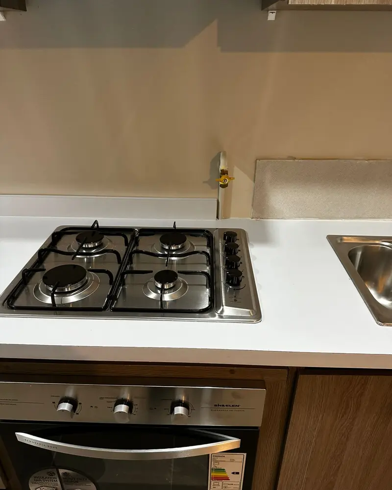 Encimera a gas sobre un horno empotrado en un mueble de cocina