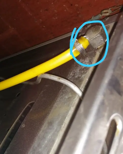Flexible de gas amarillo conectado a una cocina