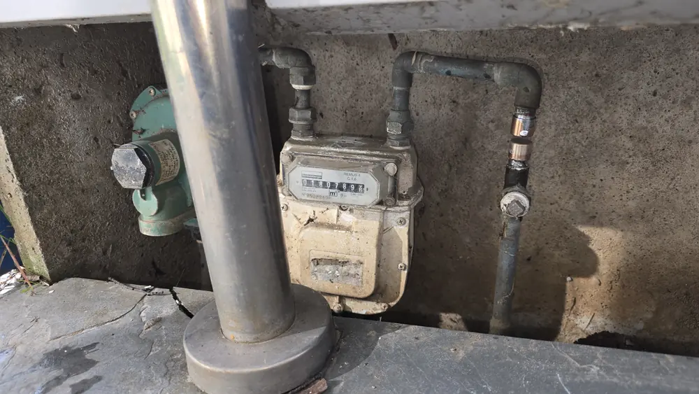 Medidor de gas en un nicho de concreto junto a su llave de paso