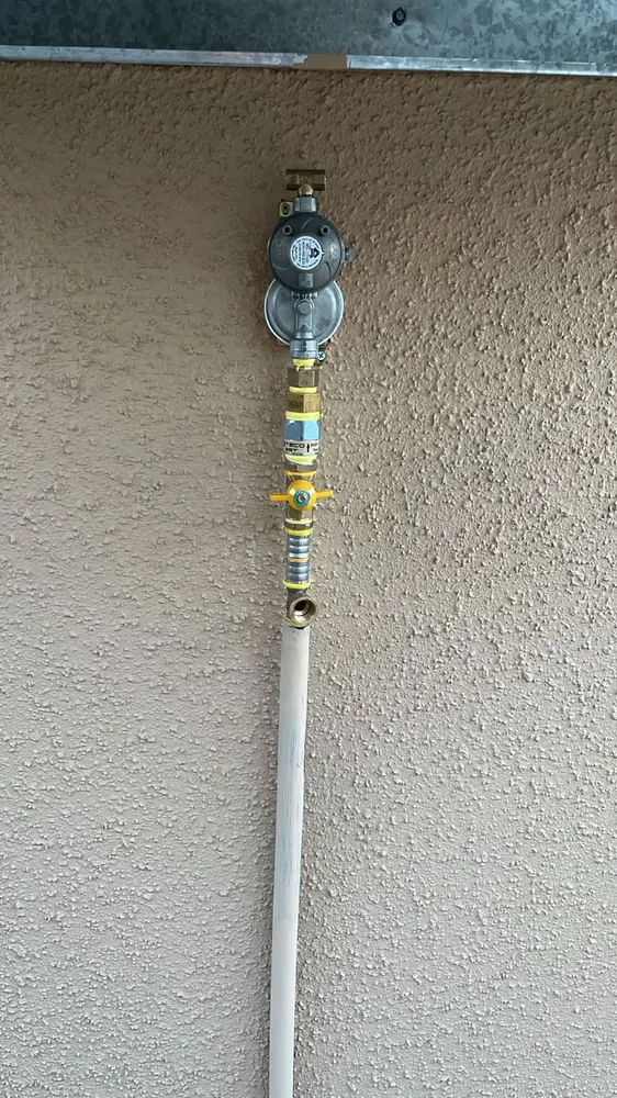 Regulador de gas con cañería vertical fijada a un muro exterior