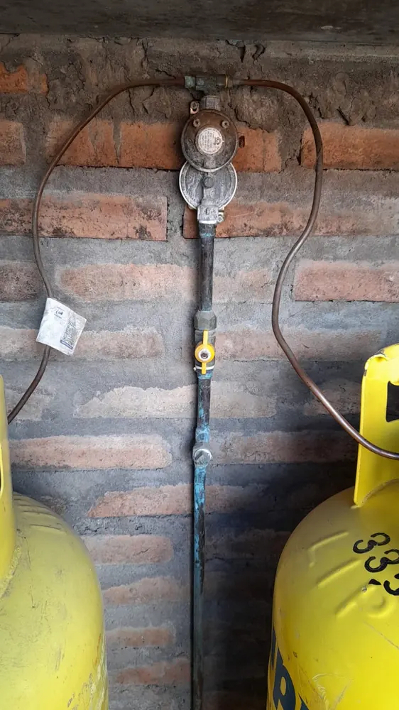 Reguladores de gas en un muro de ladrillo sobre dos cilindros