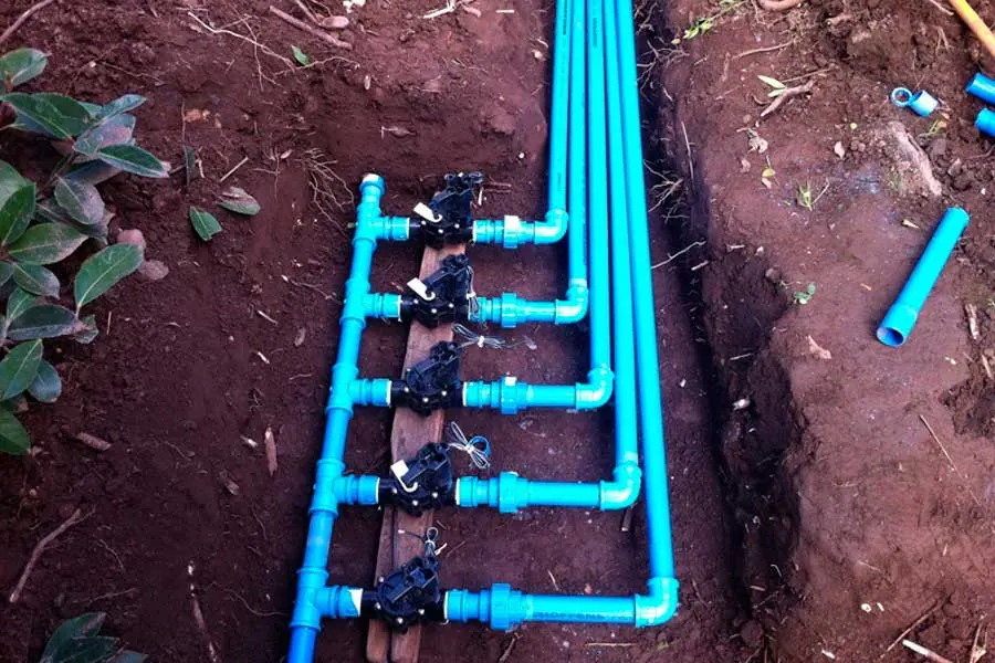 Colector de PVC con cinco electroválvulas en una zanja antes de taparla