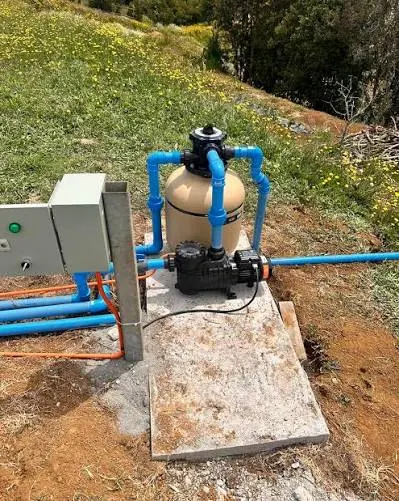 Filtro y bomba sobre base de hormigón con tablero al lado